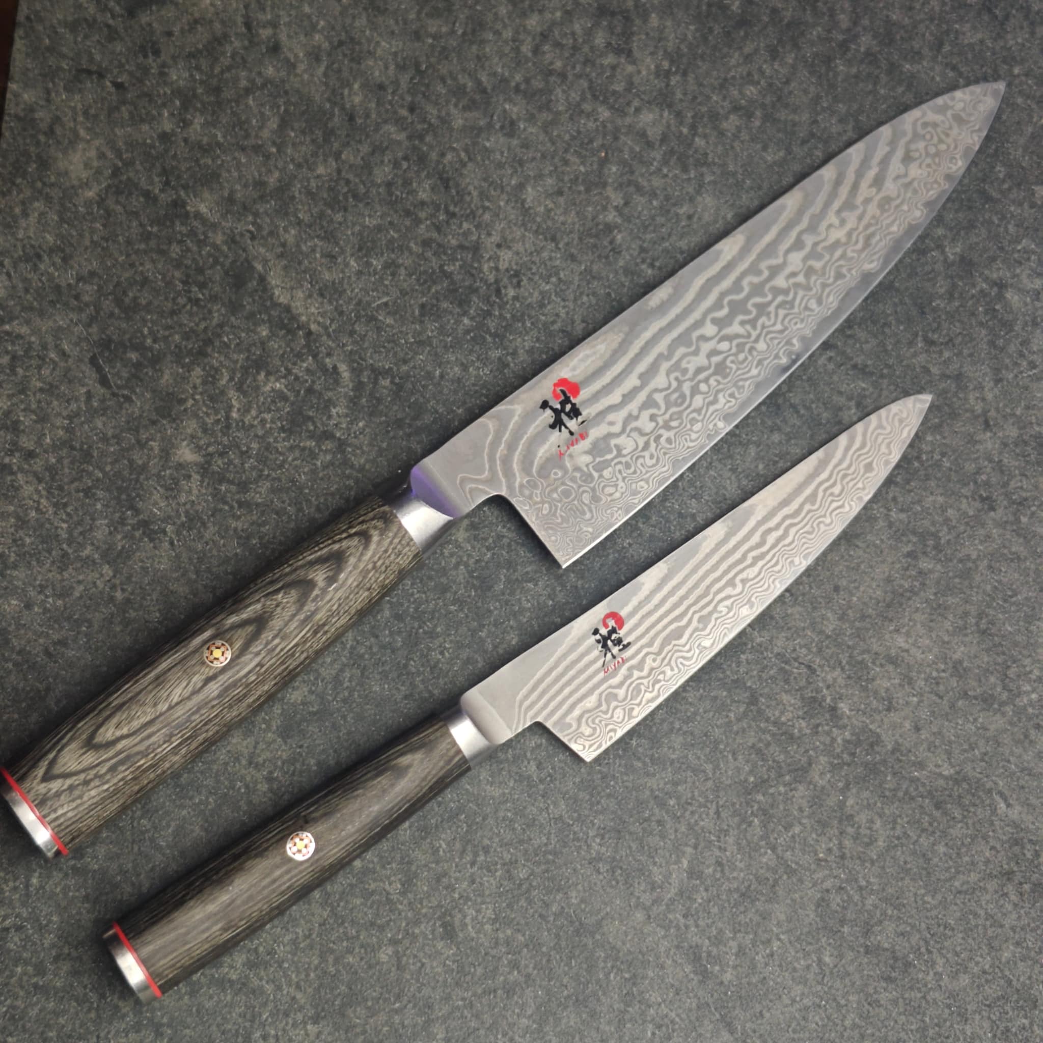 Two Damascus chef knives with wooden handles