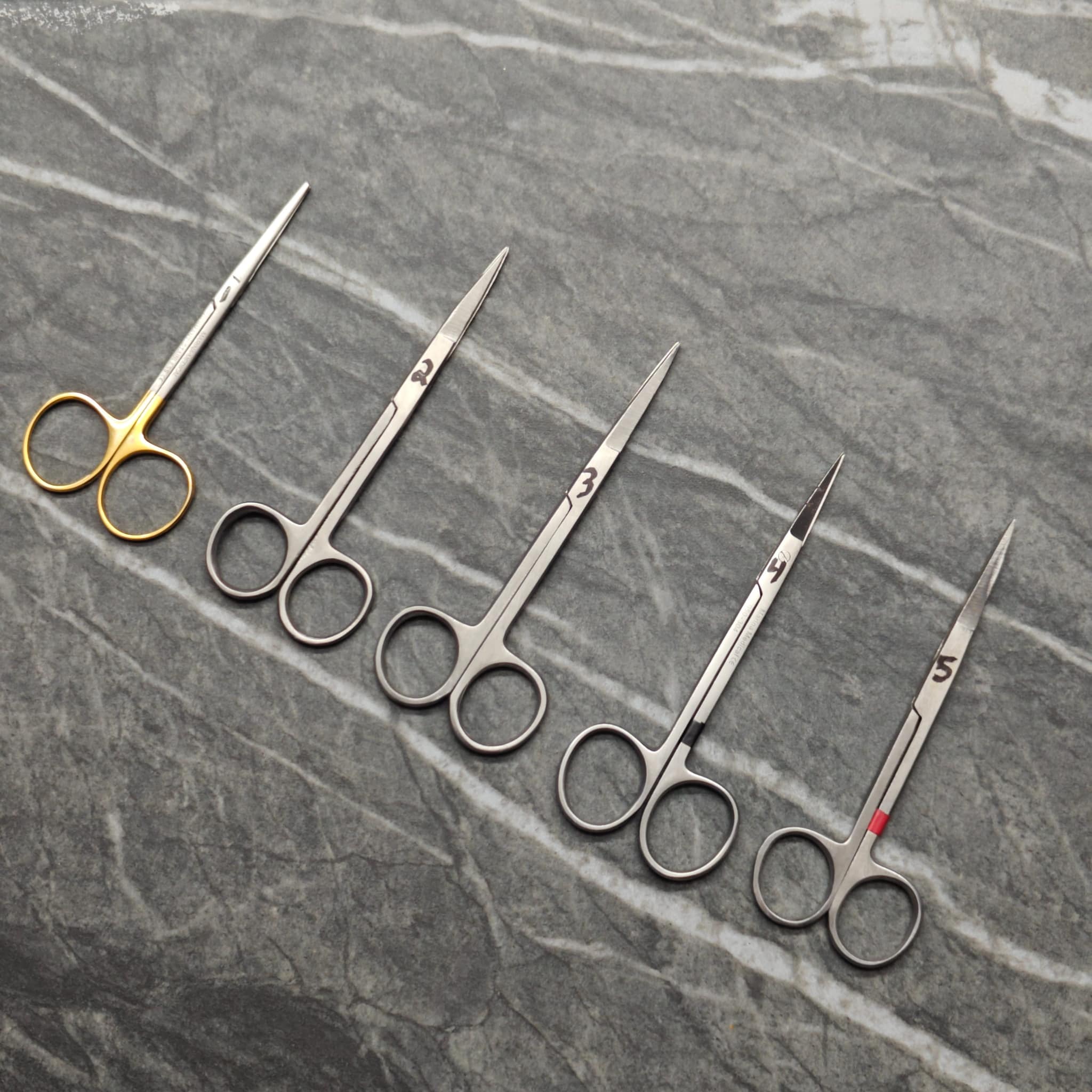 Precision scissors with gold and silver finishes arranged on cutting mat