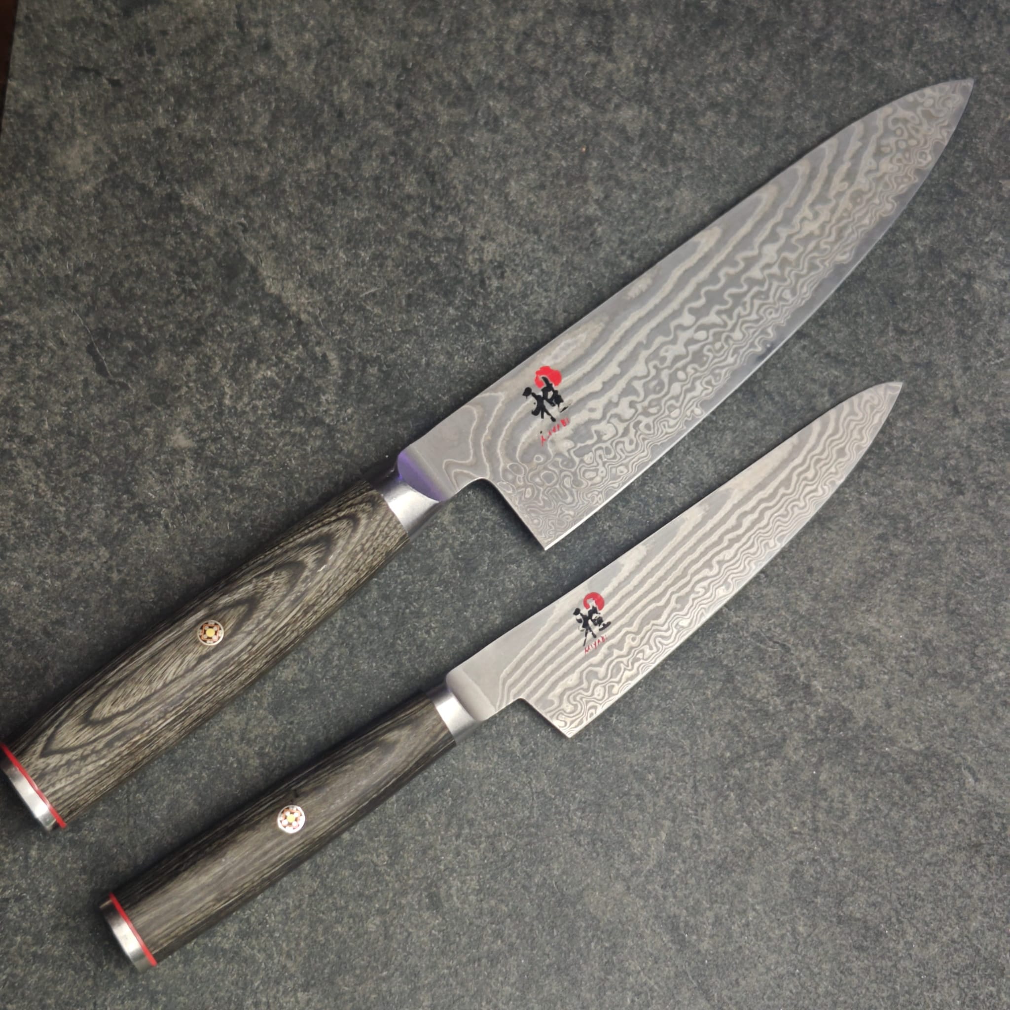 Two Damascus chef knives with wooden handles