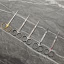 Precision scissors with gold and silver finishes arranged on cutting mat