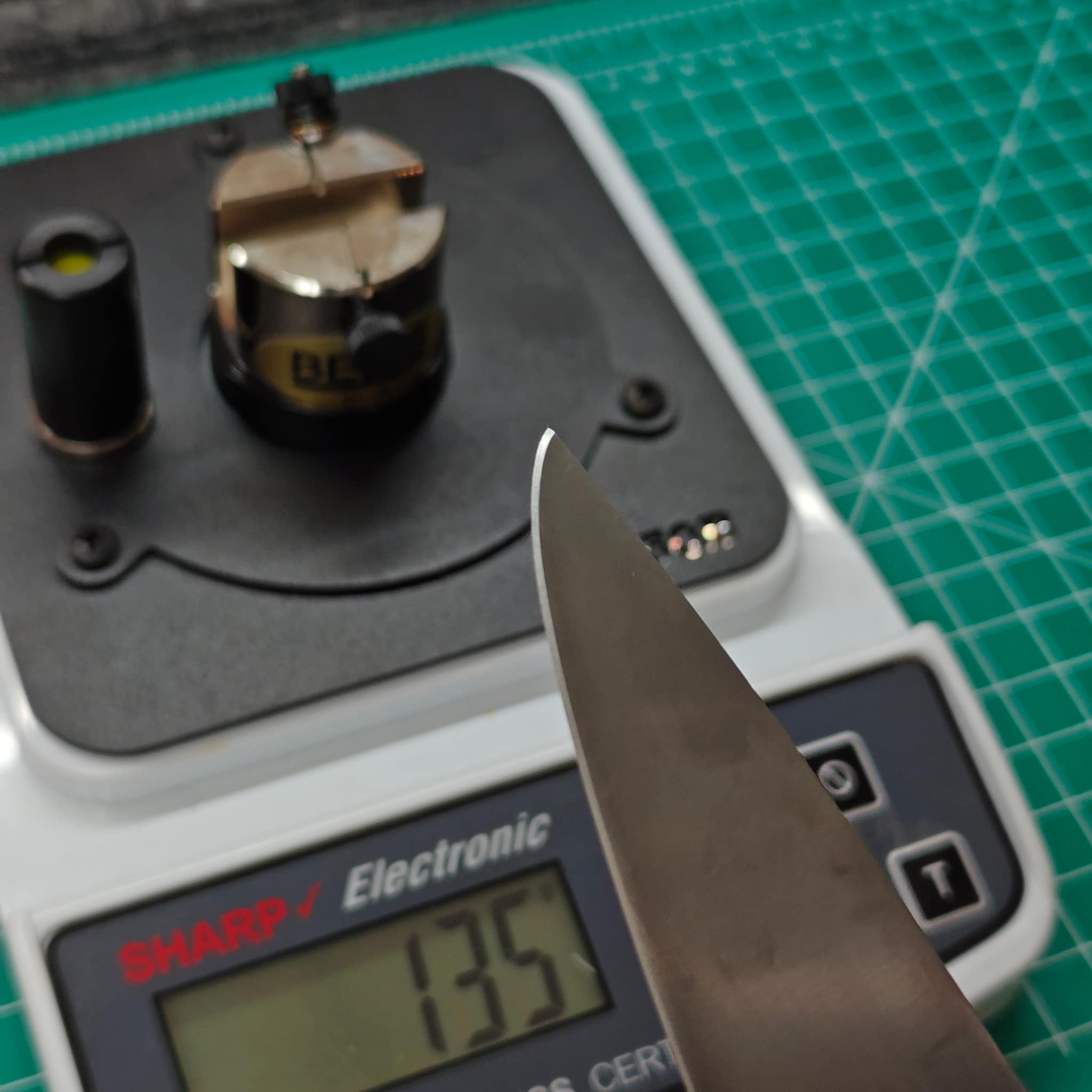 Professional knife on precision scale with sharpening equipment