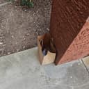 Brown paper bag with knives left at porch corner