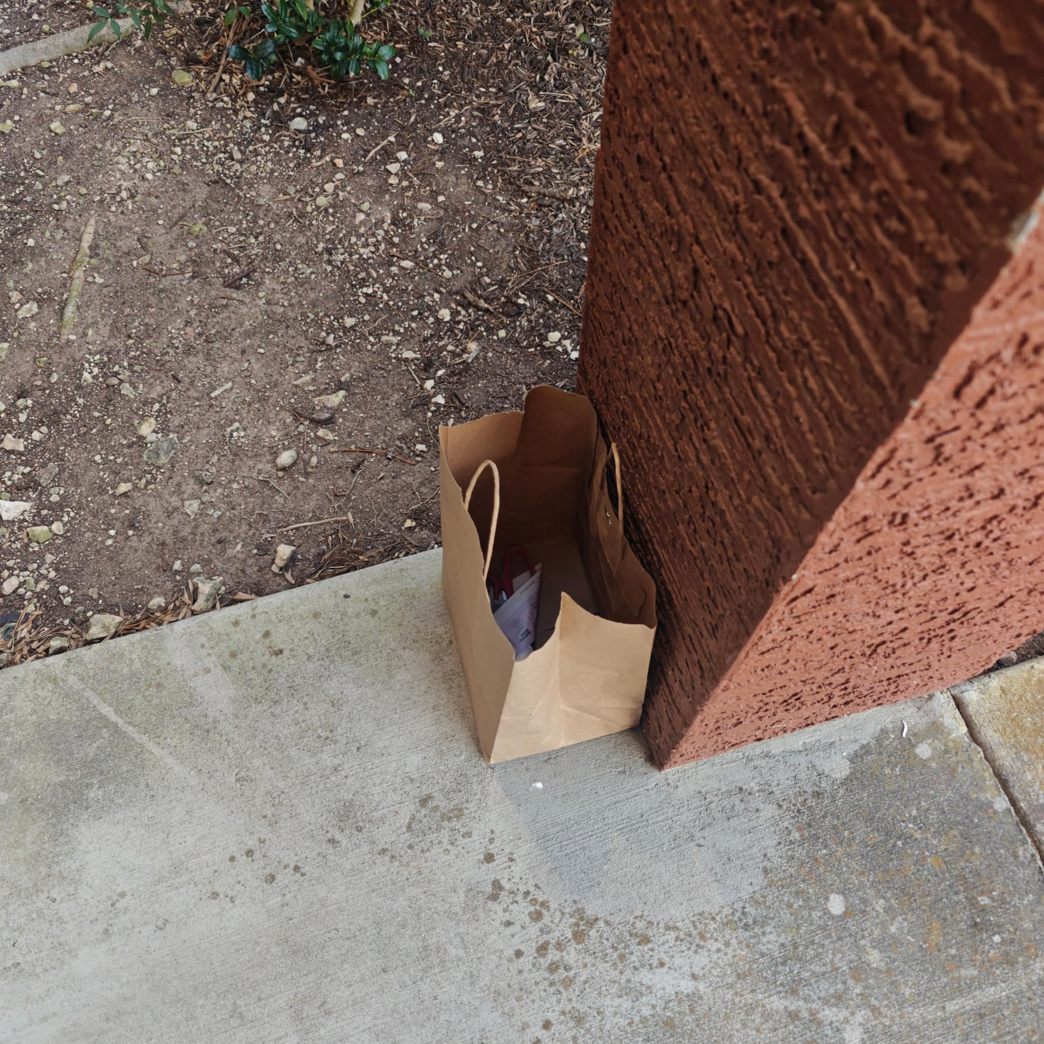 Brown paper bag with knives left at porch corner